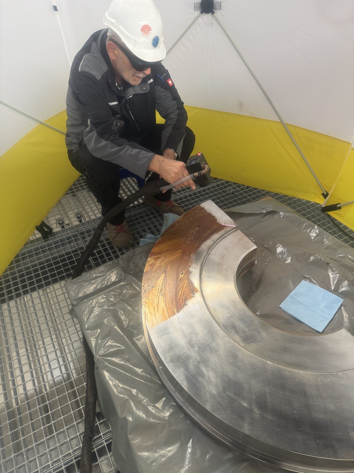 Reinigungsarbeit mit dem Laser an einem industriellen Metallbauteil.