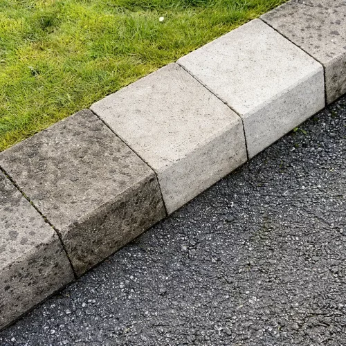 Laserreinigung reinigt stark verschmutzte Bordsteinkante und Betonsteine sichtbar